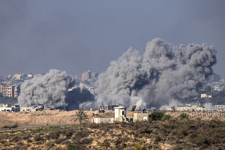 Smoke billowing from conflict-stricken urban landscape
