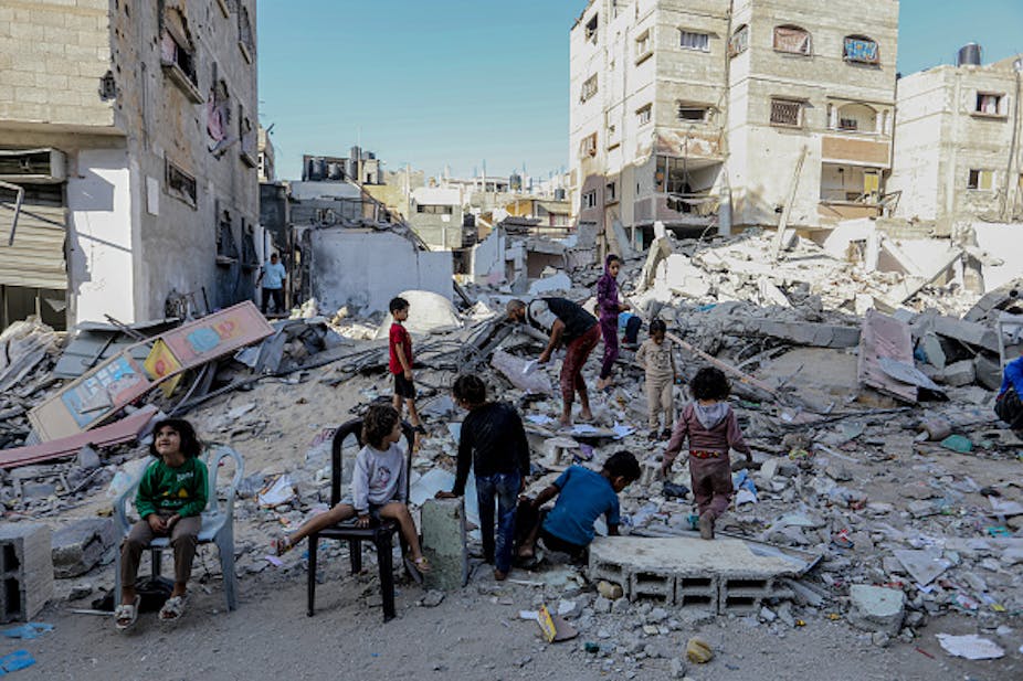 Children at the rubble of houses bombed by Israel.  