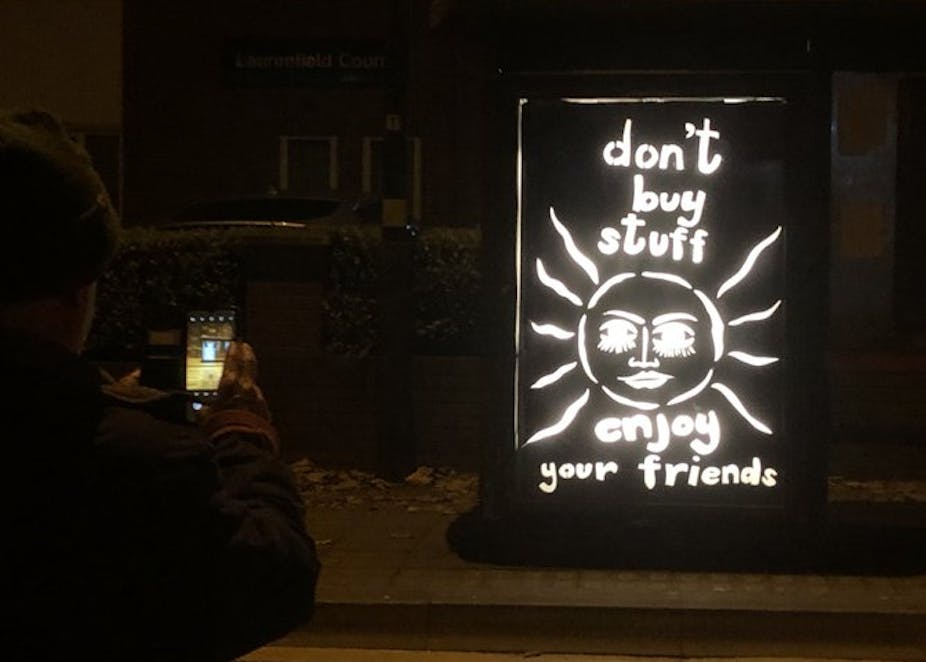 A billboard saying 'don't buy stuff, enjoy your friends'. 
