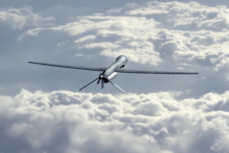 an unmanned drone looking like a slim small airplane among clouds