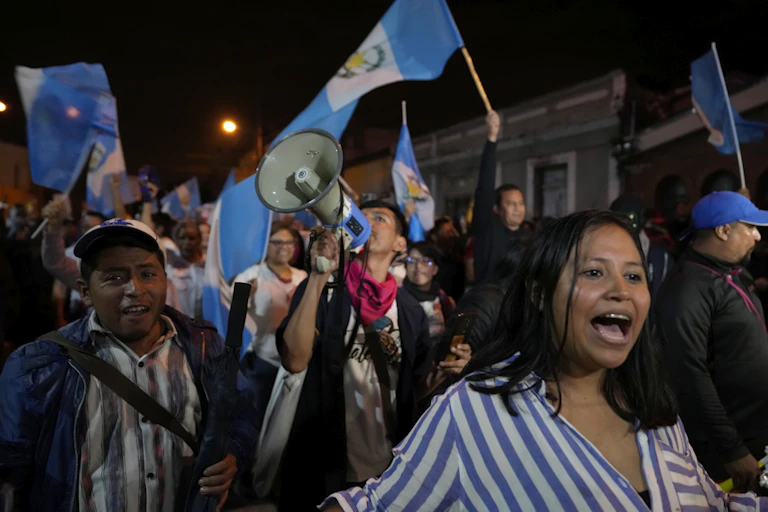 Une foule manifeste, avec une femme à l'avant-plan