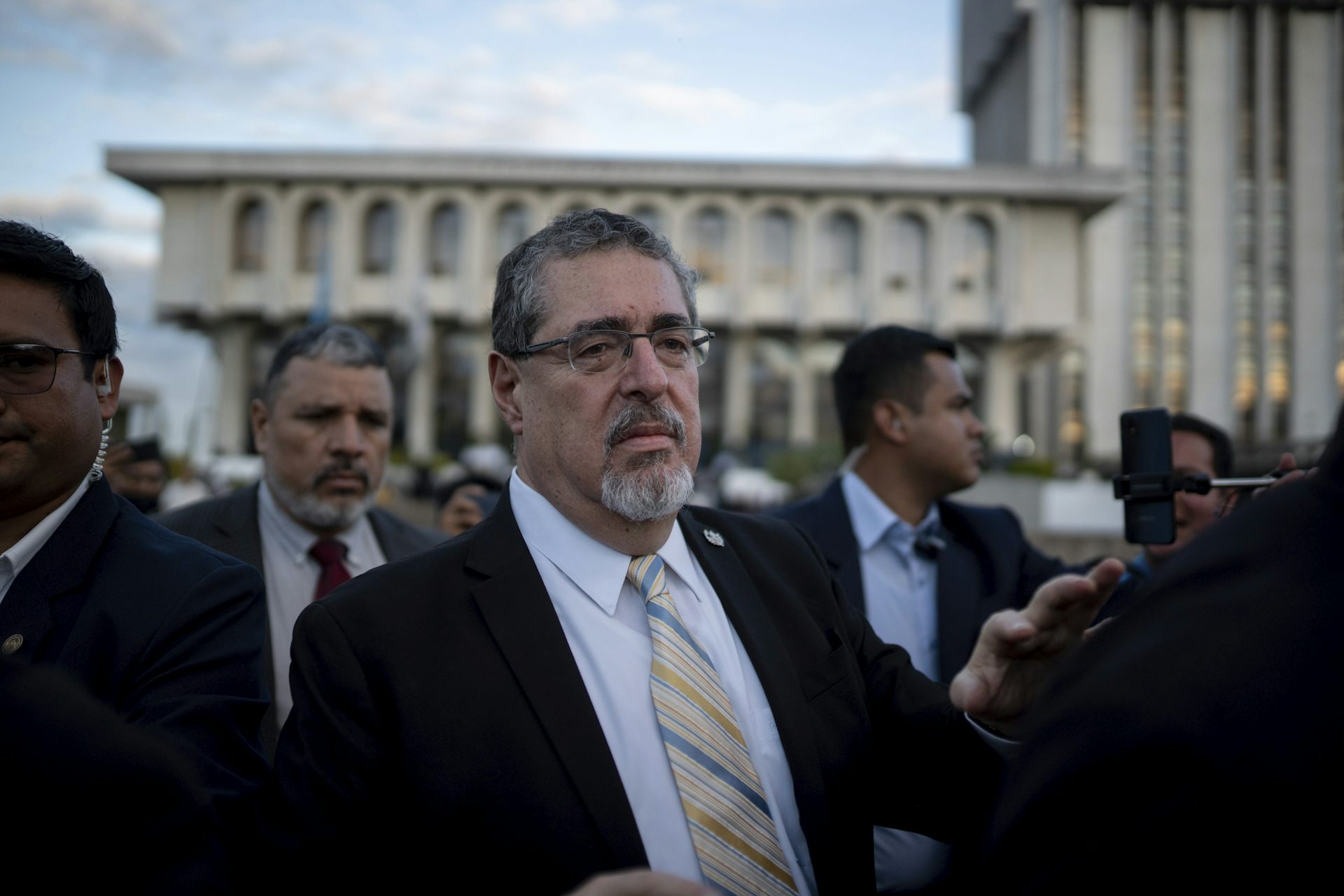 Le président élu du Guatemala marchant dans la rue, entouré d’hommes