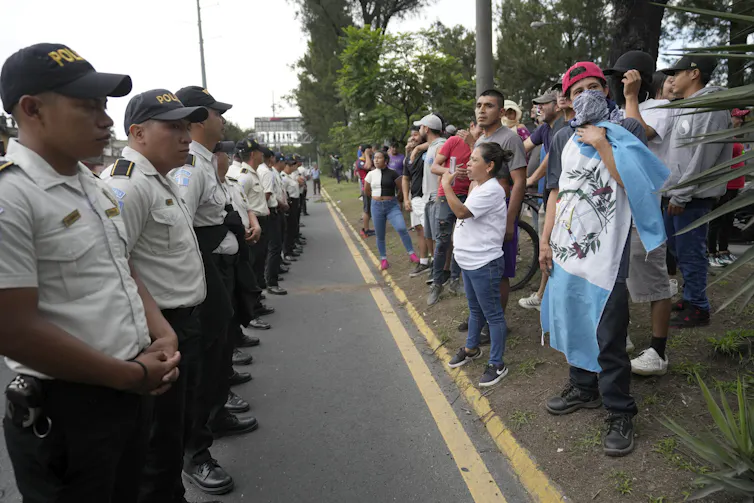 Une rangée de policiers face à des manifestants