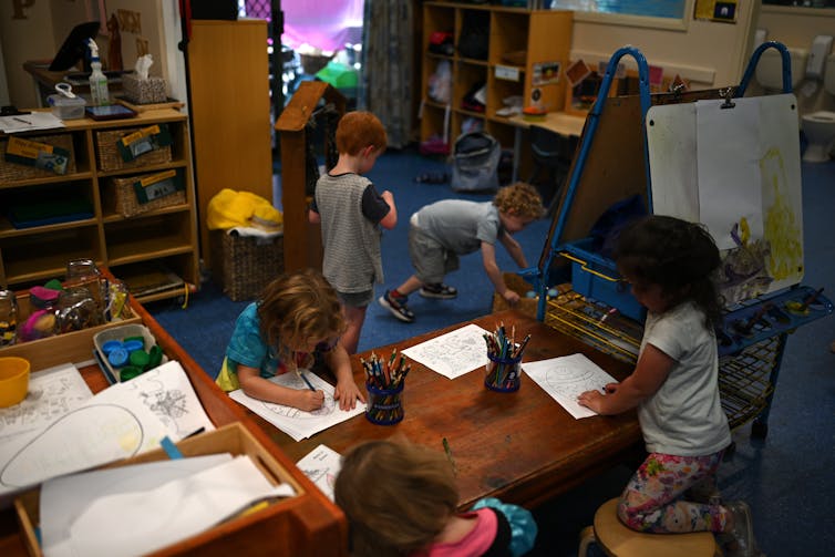 Children draw and play in a childcare centre.