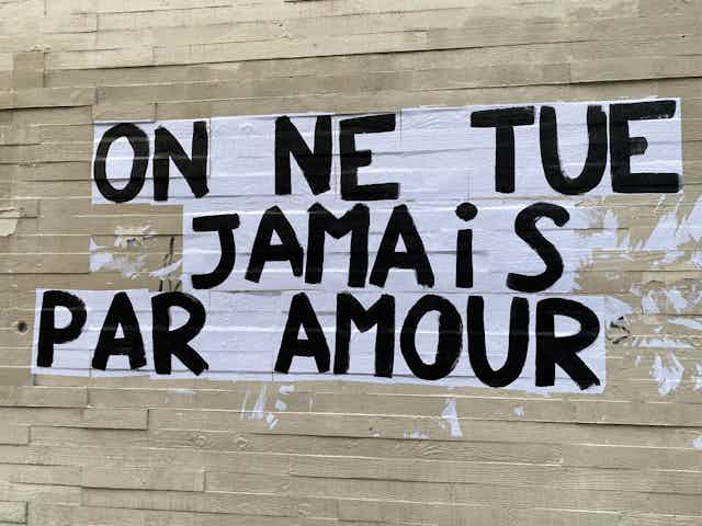 Collage sauvage avec la phrase "On ne tue jamais par amour" sur un mur de Paris.