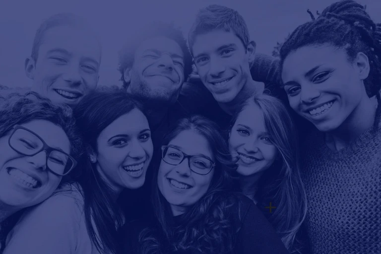 Un groupe de jeunes gens souriant et se tenant par les bras.