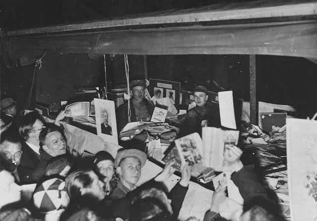 Alemanes se agolpan alrededor de un camión lleno de libros "no alemanes", confiscados de la biblioteca del Instituto de Ciencias Sexuales, para ser quemados por los nazis.