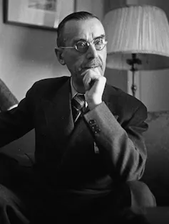 Retrato de un hombre delgado y con gafas que apoya su barbilla en la mano.