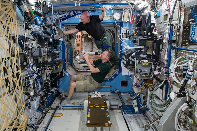 Dois astronautas trabalham num laboratório em gravidade zero, a bordo de uma estação espacial