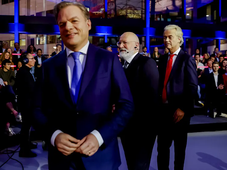 Pieter Omtzigt with Geert Wilders in the background in a TV studio.