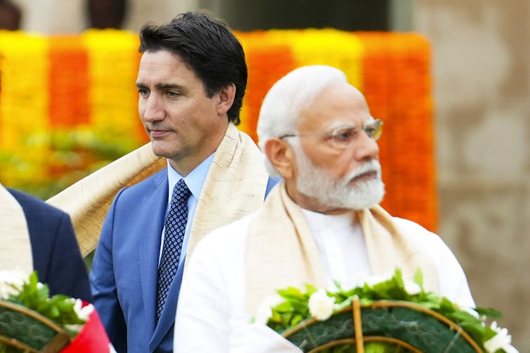 Narendra Modi with Justin Trudeau standing in the background