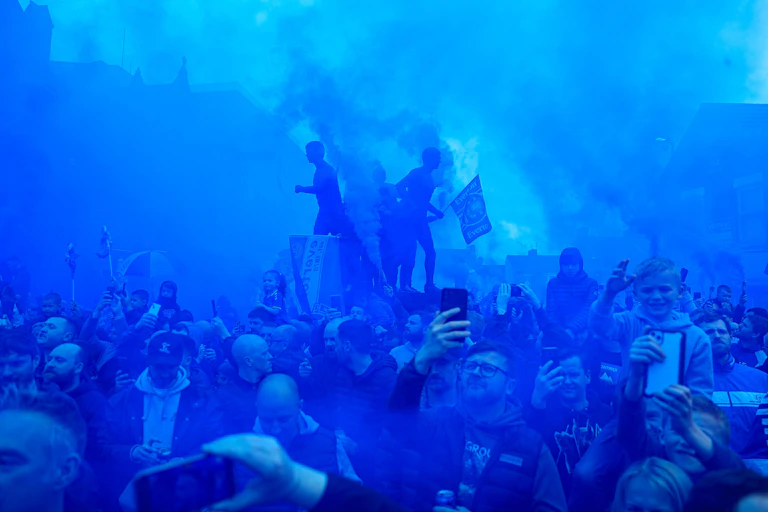 Everton fans gather in blue smoke.