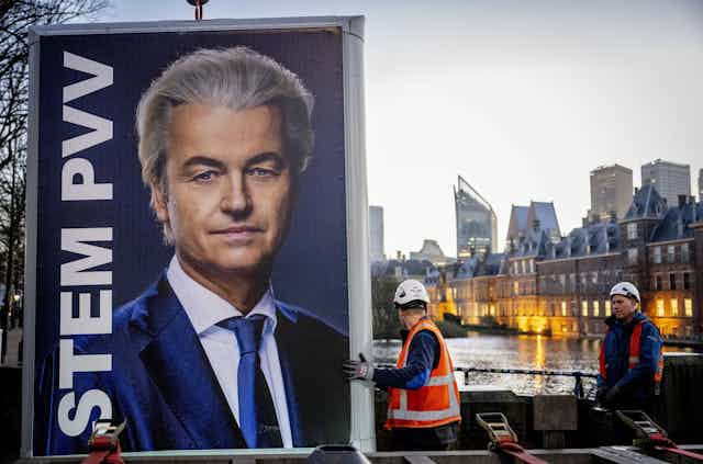 Workmen hoist a huge image of Geert Wilders in to place. 