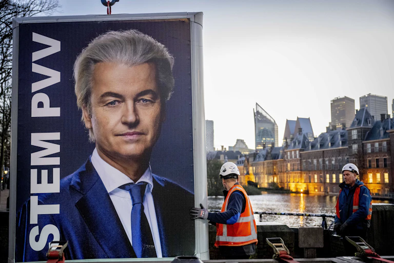 Workmen hoist a huge image of Geert Wilders in to place.