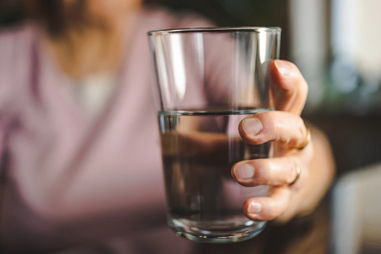 Hand holding glass of water