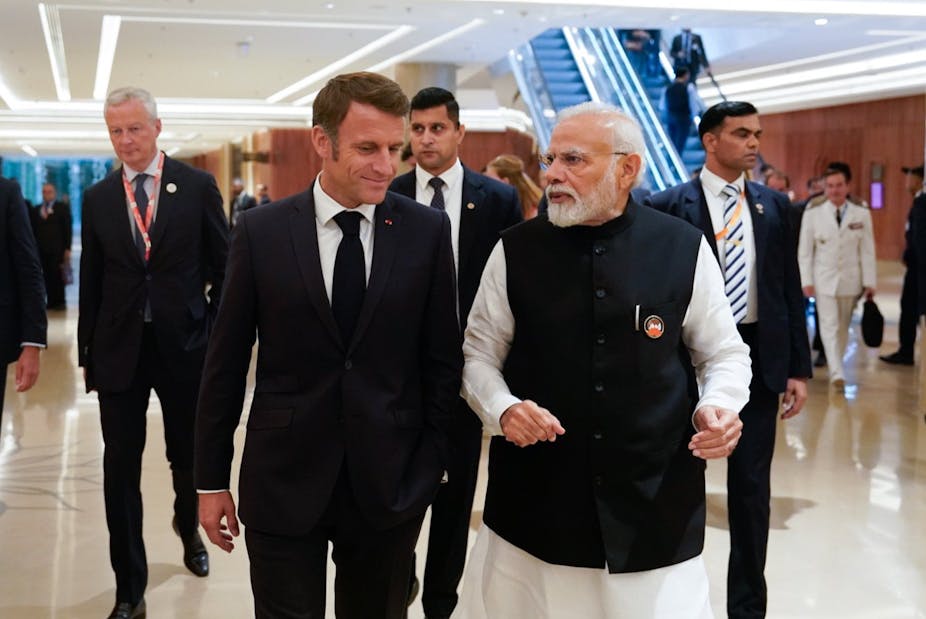 Emmanuel Macron discute avec Narendra Modi en marchant dans un hall