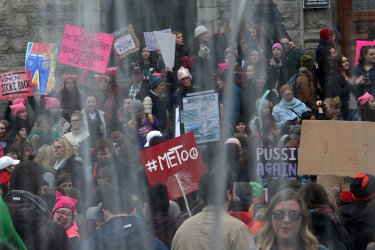 Demonstrators seen outside, some in pink hats.