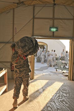 Un soldado estadounidense lleva una bolsa de lona a la zona de carga.