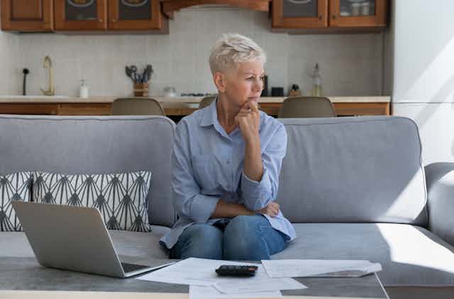 Woman looking worried with bills and calculator.
