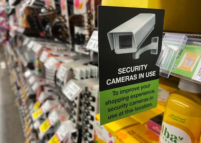 A sign in a supermarket aisle saying security cameras in use