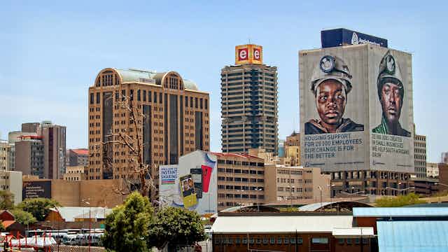 a cityscape with a billboard of two mining workers