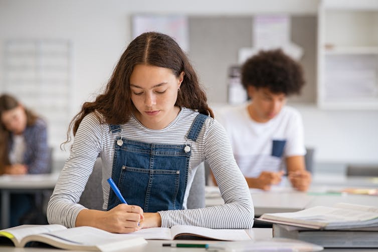 A teenage girl studies in class