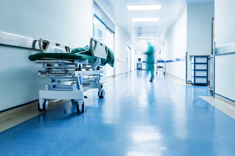 Doctors or nurses walking in hospital hallway, blurred motion.