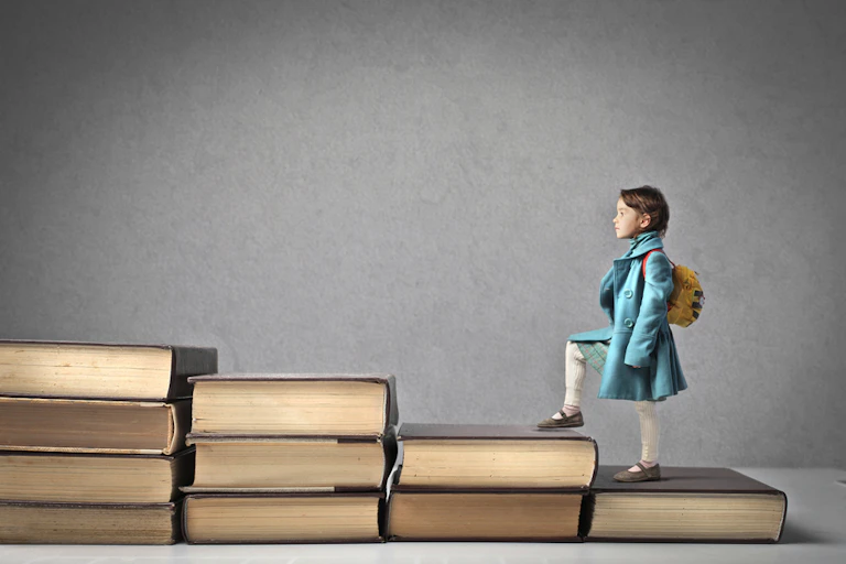 Une petite fille avec un cartable montant un escalier de livres.