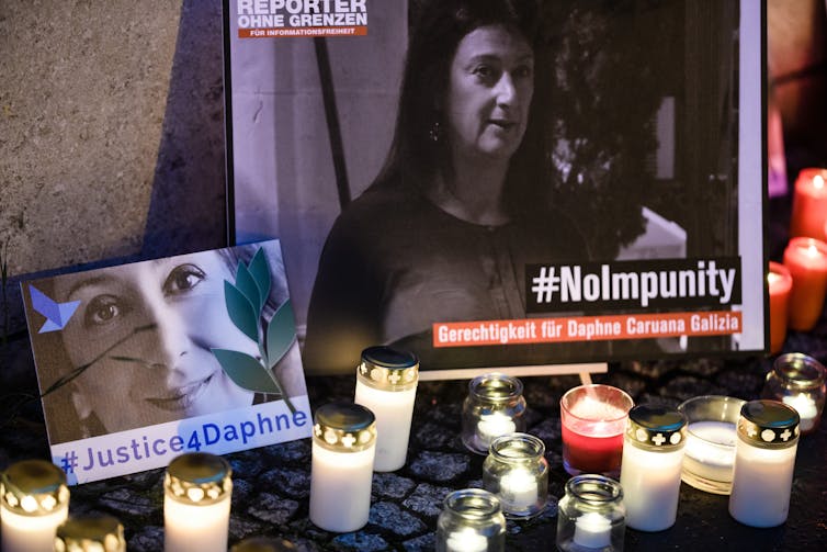 Candles and pictures of Daphne Caruana Galizia at shrine to her memory