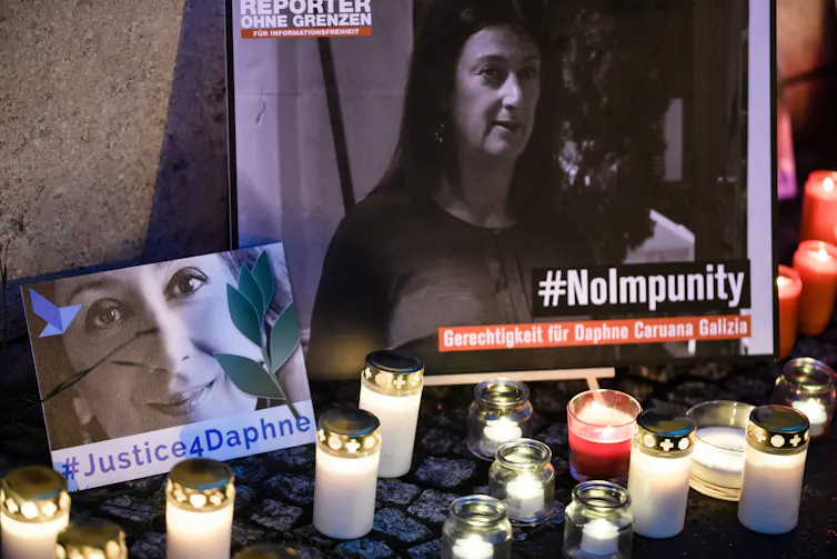 Candles and pictures of Daphne Caruana Galizia at shrine to her memory