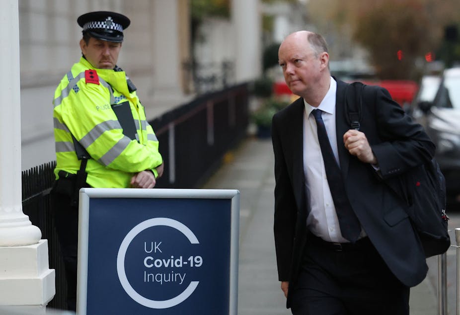 Chris Whitty walking into a building past a sign that says UK covid-19 inquiry.