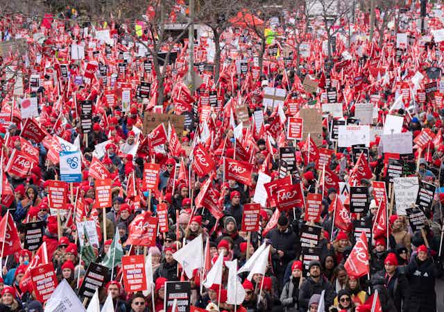 Enseignants en grève brandissant des pancartes et des drapeaux rouges