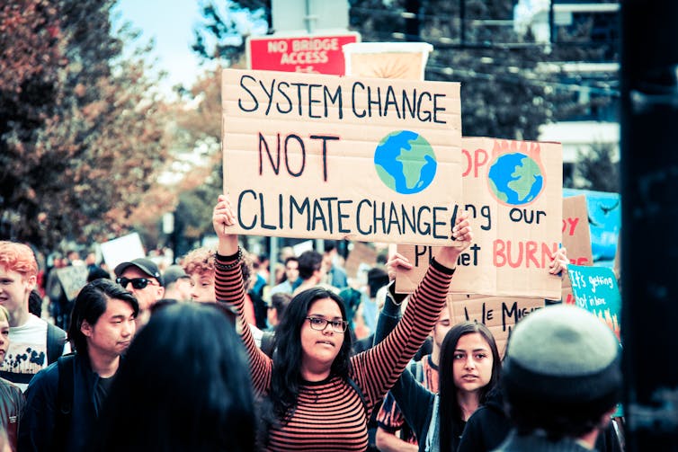 Manifestation où l’on peut voir une pancarte : System change not climate change.