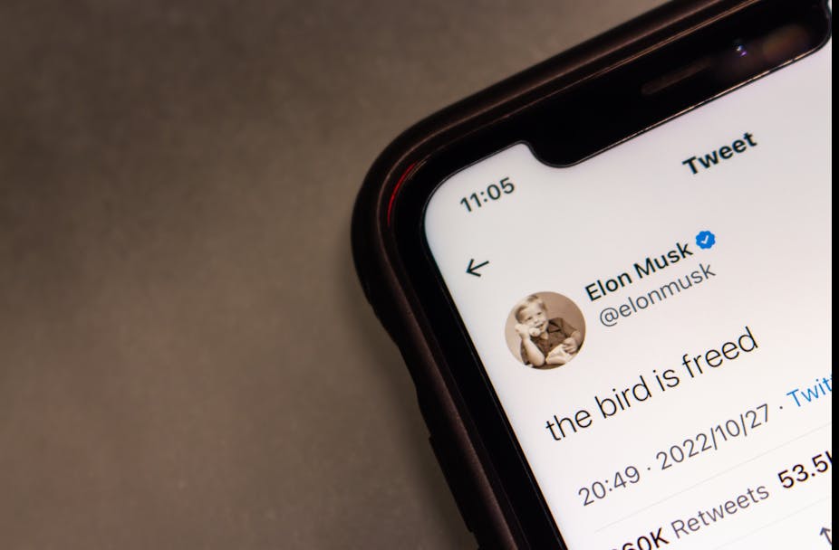 Photo d'un téléphone sur lequel est visible un tweet d'Elon Musk : « the bird is freed »