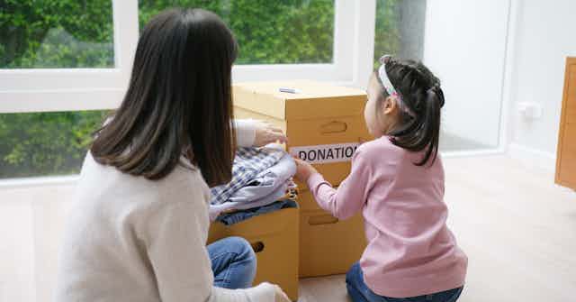 A mother and daughter pack donations into boxes.