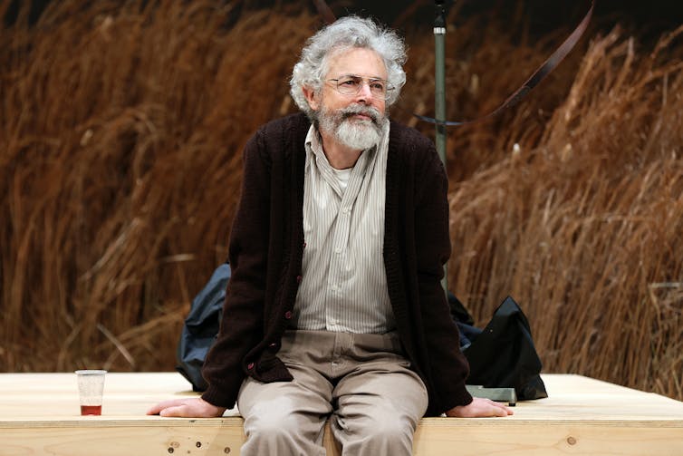 A man sits on a deck.