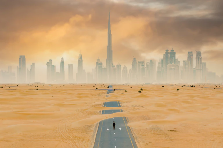 road to dubai covered in sand, big city,