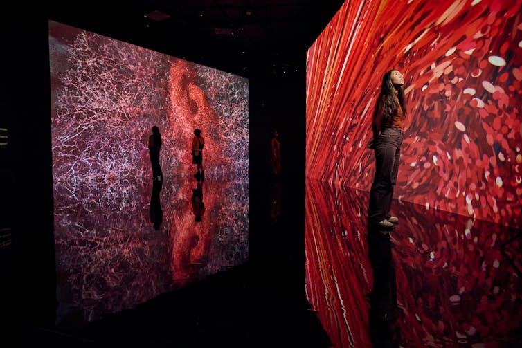 People stare at large screens with red.