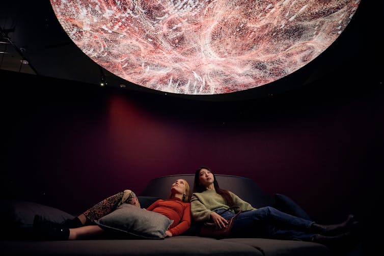 People look at a projection above.