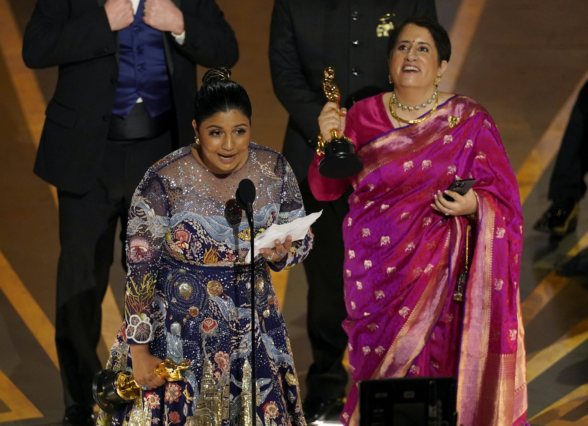People standing at a podium accepting an award.