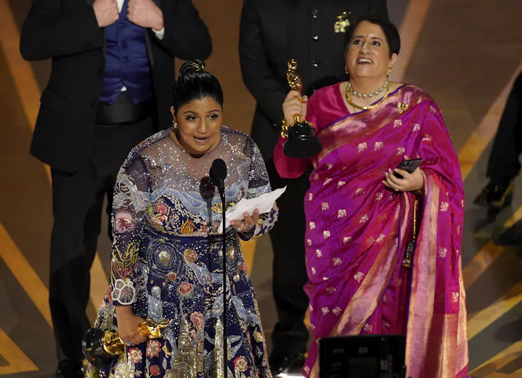 People standing at a podium accepting an award.