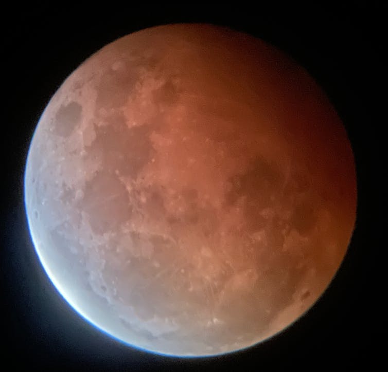 Vista ingrandita della Luna con un lato in una tonalità di rosso