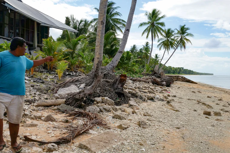 Un homme sur une île montre la plage en contrebas