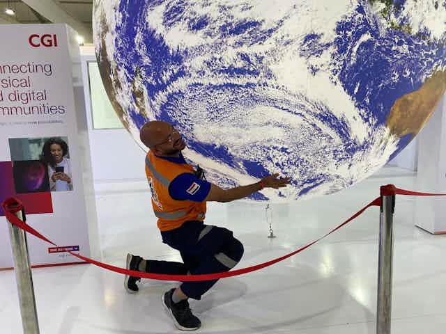 En marge de la COP27 à Charm el-Cheikh en 2022, un homme déplace un globe en forme de Terre