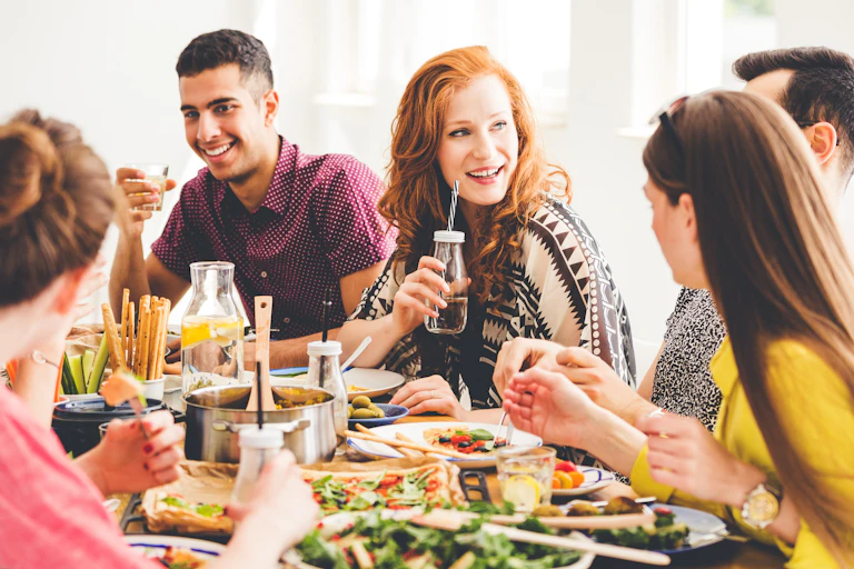 Des jeunes gens sont attablés pendant un repas végétarien