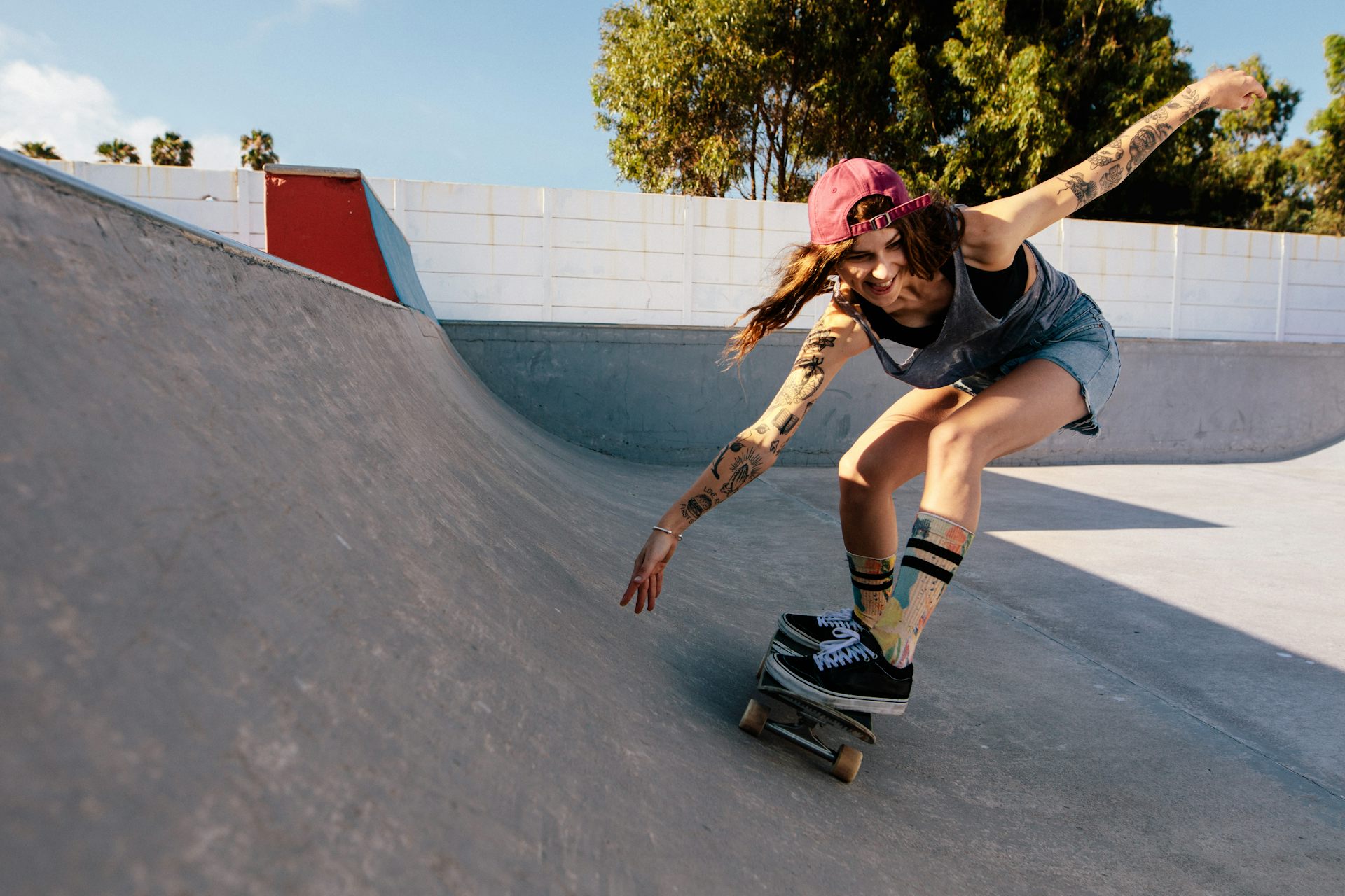 A young woman on a skateboard in a skatepark.