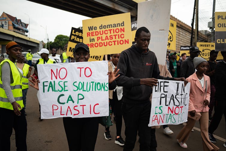 People march with signs calling for limits on plastic production.
