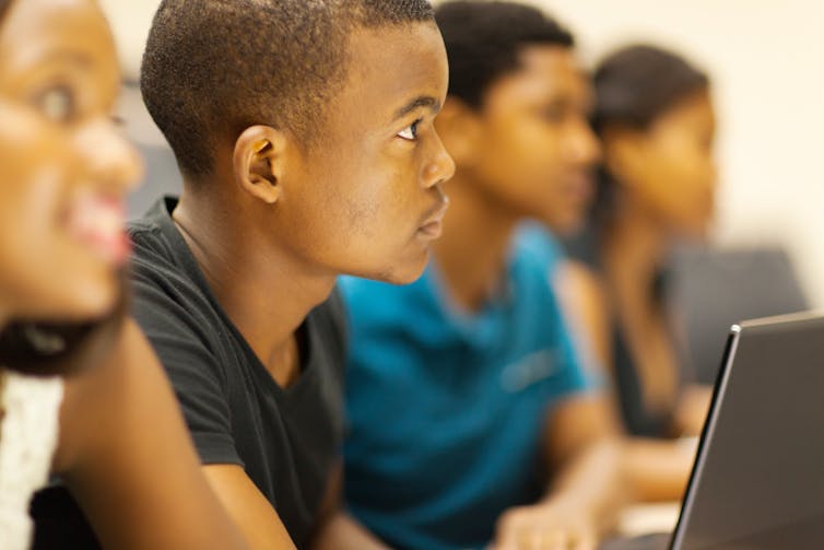 A Black boy sitting in a class room