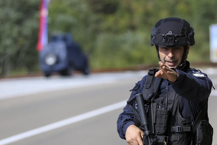 A man in uniform gestures.