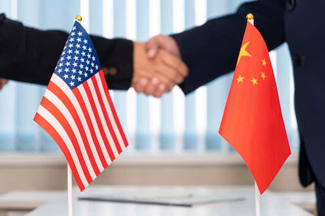 US and China flags with handshake in background